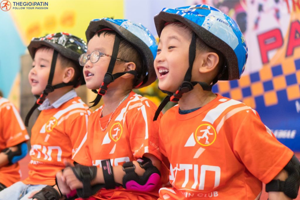 Bé gái mặc quần áo thể thao màu hồng và trắng, đang mang giày trượt patin có đèn màu hồng tươi tắn, biểu cảm vui vẻ, sẵn sàng cho hoạt động giải trí.