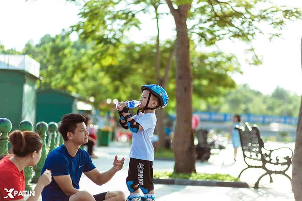 Bé trai 6 tuổi đang vui vẻ trượt patin cùng bạn bè tại công viên