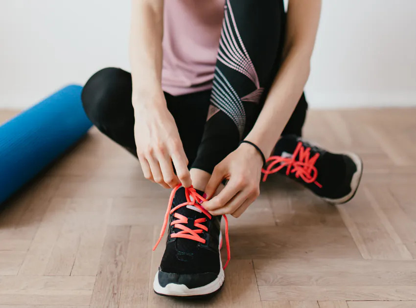 Cận cảnh một đôi giày sneaker với dây giày được cột một cách gọn gàng và tinh tế, tăng thêm vẻ cuốn hút cho trang phục