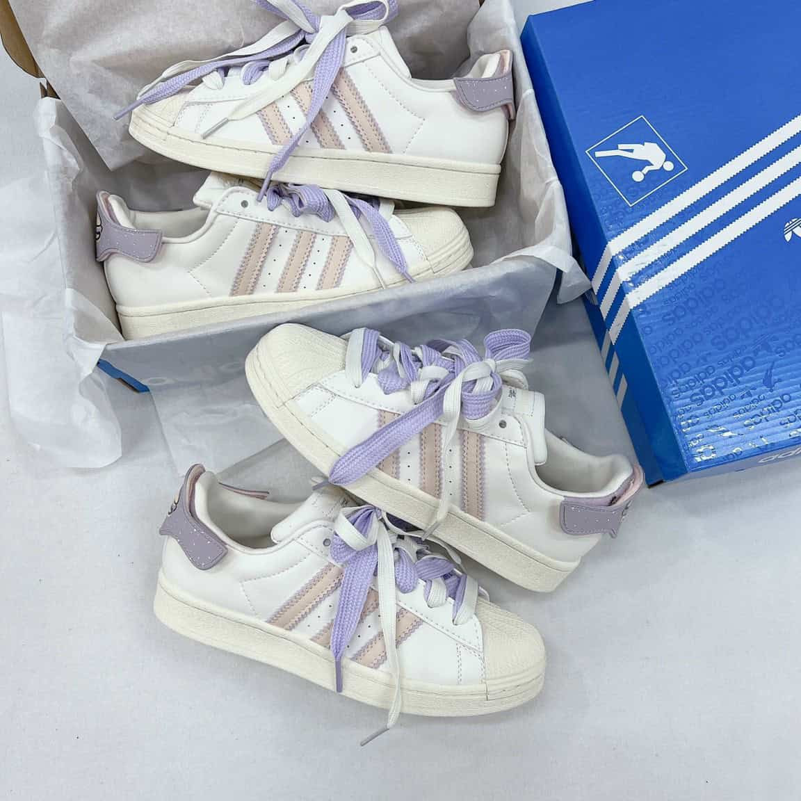 Cặp đôi mang giày thể thao Adidas Superstar màu trắng cổ điển