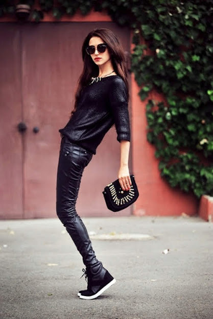 Cô gái diện áo khoác biker đen, quần jeans đen và giày thể thao đỏ đen