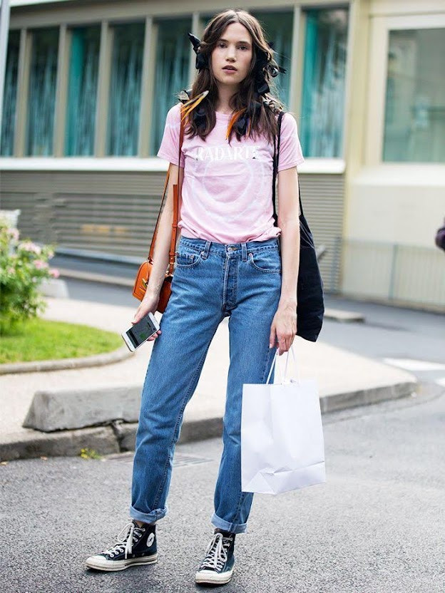 Cô gái diện áo khoác bomber, áo phông trắng, quần jeans xanh và giày thể thao cao cổ đen