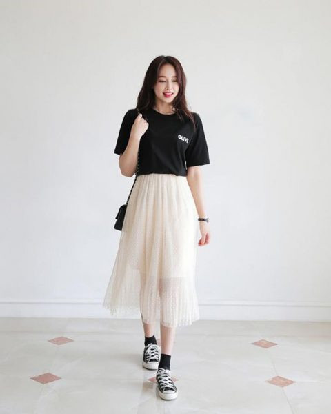 Cô gái diện chân váy maxi màu be, áo phông trắng và giày thể thao trắng năng động