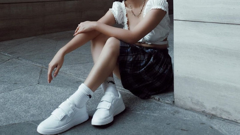 Cô gái kết hợp giày thể thao trắng với váy ngắn trên gối và áo blazer