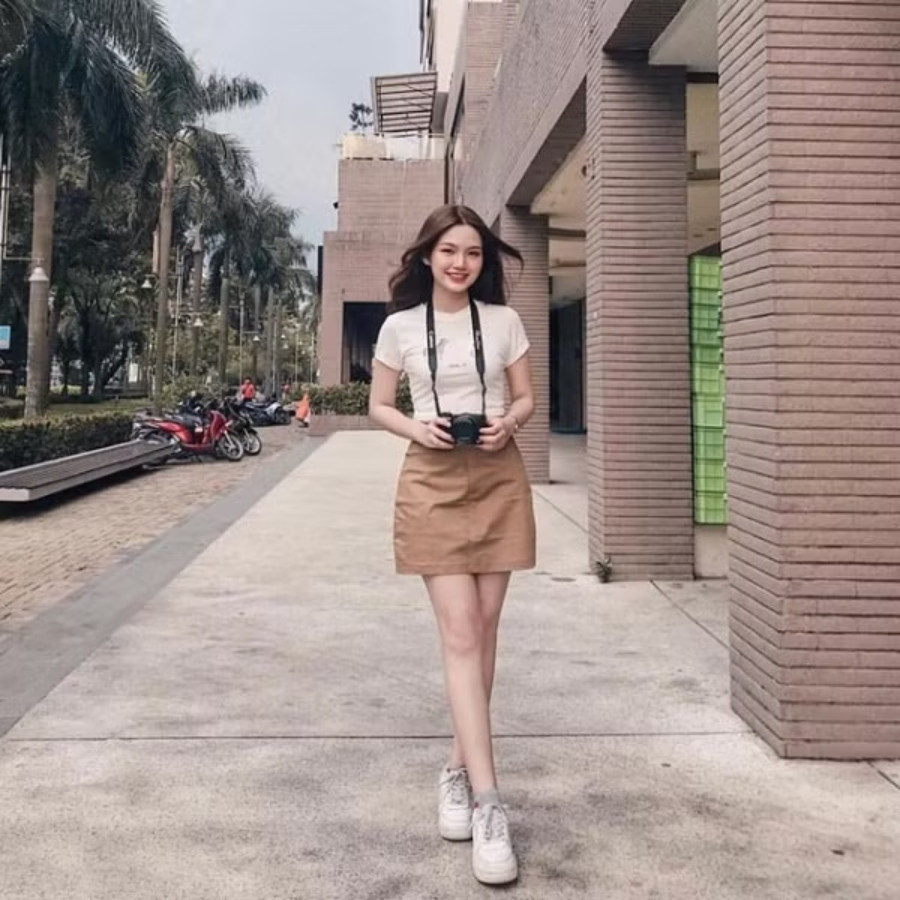 Cô gái mặc chân váy chữ A denim phối giày sneaker trắng cá tính