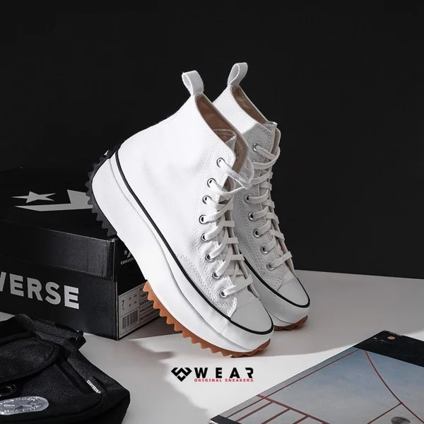 Cô gái trẻ trung trong vest và giày Converse đế bánh mì