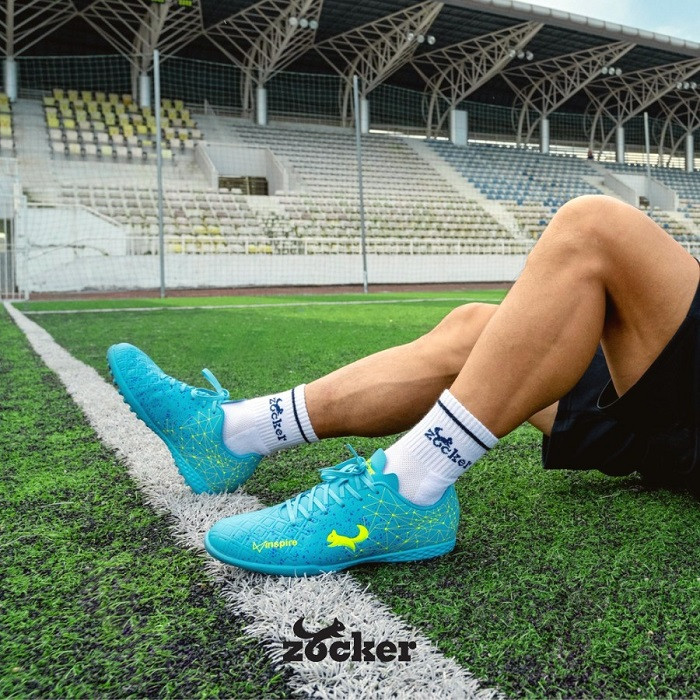 Đôi giày bóng đá Zocker màu xanh nổi bật, thể hiện chất lượng và thiết kế của thương hiệu.