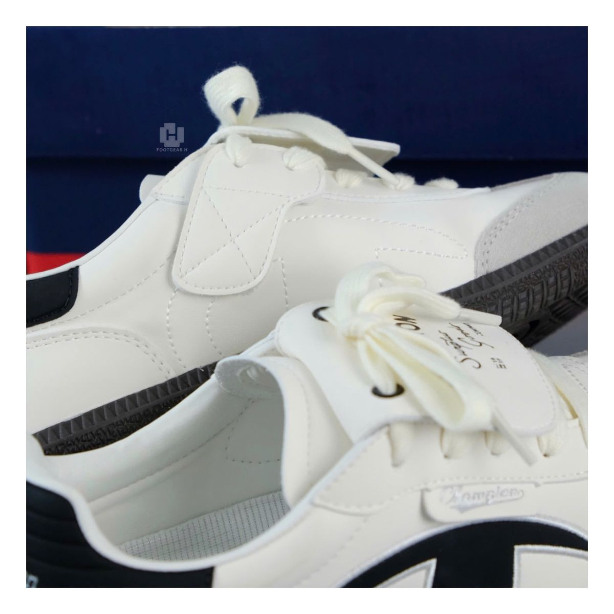 Đôi giày Champion Essentials Champ T-Trainer màu kem và đen đặt trên nền trắng