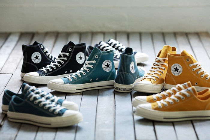 Đôi giày Converse Chuck Taylor All Star màu trắng trên sân bóng rổ, biểu tượng của giày bóng rổ Converse.