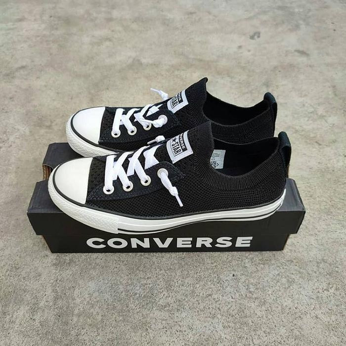 Đôi giày lười vải nam Converse màu đỏ nổi bật trên nền gỗ