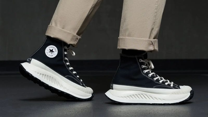Đôi giày sneaker cổ cao màu đen giúp che bắp chân và tạo hiệu ứng chân dài cho người chân bè