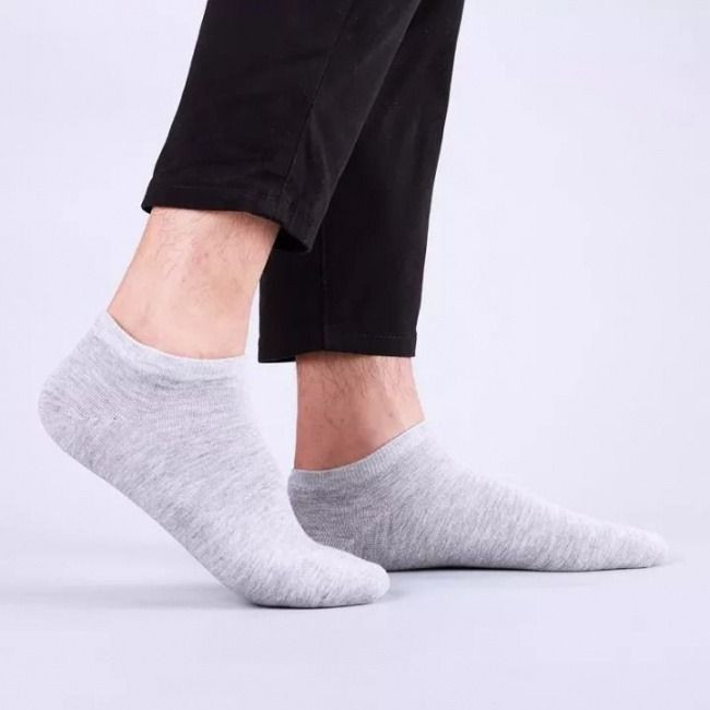 Đôi giày sneaker đen và tất cổ thấp màu xám, phù hợp cho hoạt động hàng ngày.