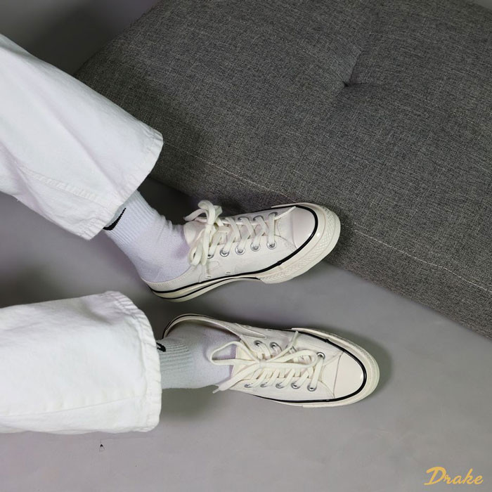 Đôi giày sục Converse nữ màu đen phối cùng quần ống rộng và tất trắng