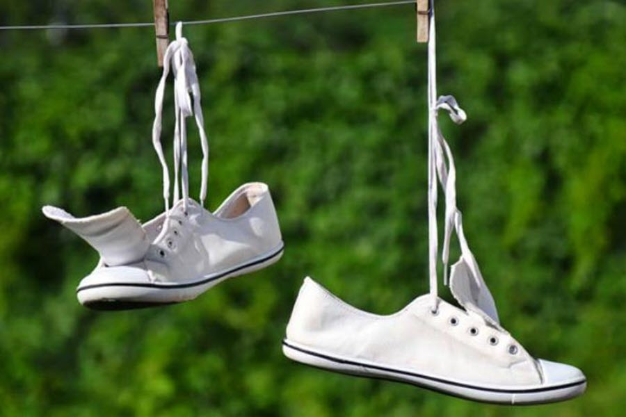 Đôi giày thể thao sạch sẽ đang được phơi khô tự nhiên trên giá, tránh ánh nắng trực tiếp