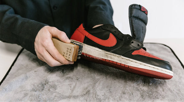 Dùng bàn chải giũ sạch bụi bẩn từ đế giày Nike
