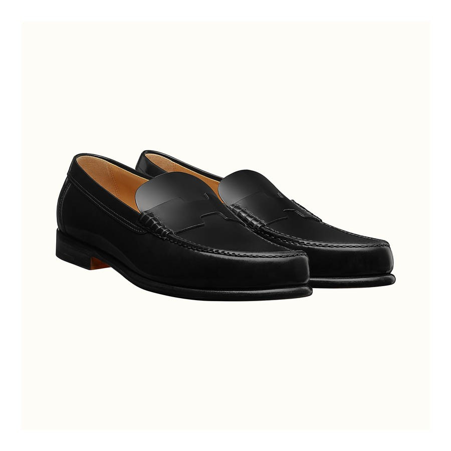 Giày lười Hermes Kennedy Leather Moccasin đen với khóa kim loại đơn giản, toát lên vẻ tinh tế, tương đồng với sự thanh lịch của giày lười có dây.