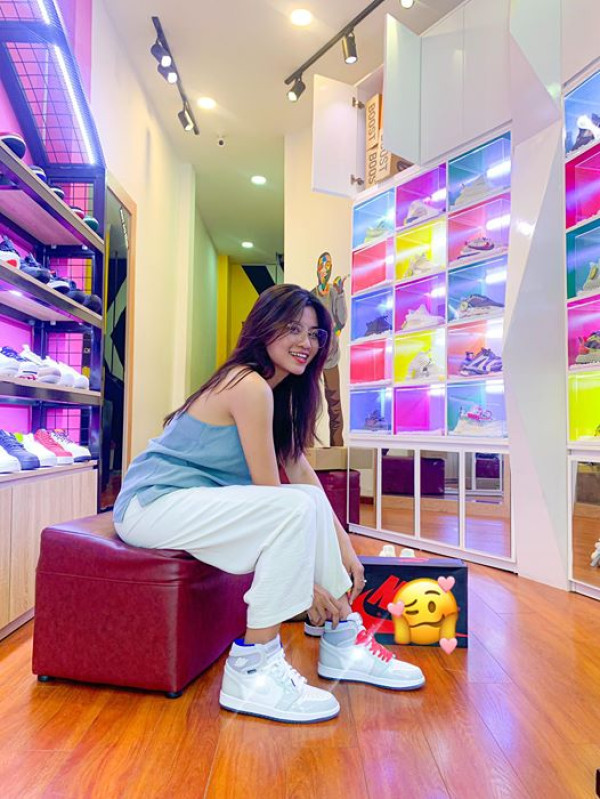 Hình ảnh một đôi giày sneaker Đà Nẵng thời trang trên nền biển xanh cát trắng.