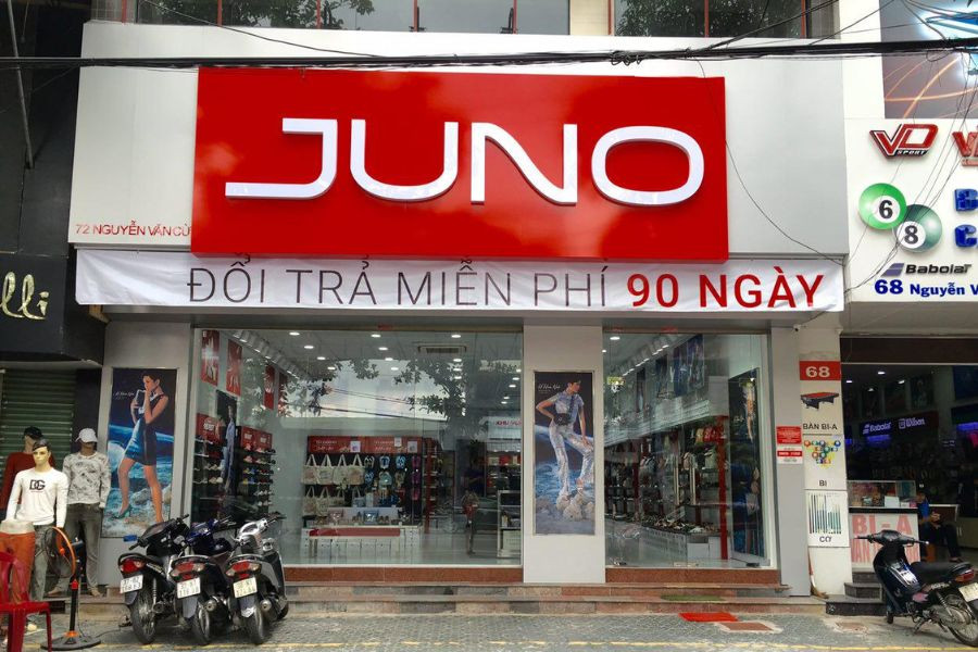 Mặt tiền cửa hàng giày thời trang với tông màu sáng và logo thương hiệu nổi bật, thu hút khách hàng nữ và nam đến các shop giày ở Vinh