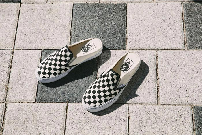 Một cô gái đang tạo dáng với đôi giày Vans Mule màu trắng đen thanh lịch, phù hợp với phong cách giày thể thao không gót