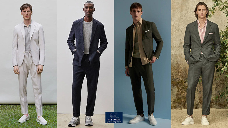 Một người đàn ông trẻ tuổi trong bộ vest màu be, quần ống lửng và giày sneaker trắng, thể hiện phong cách năng động và hiện đại.