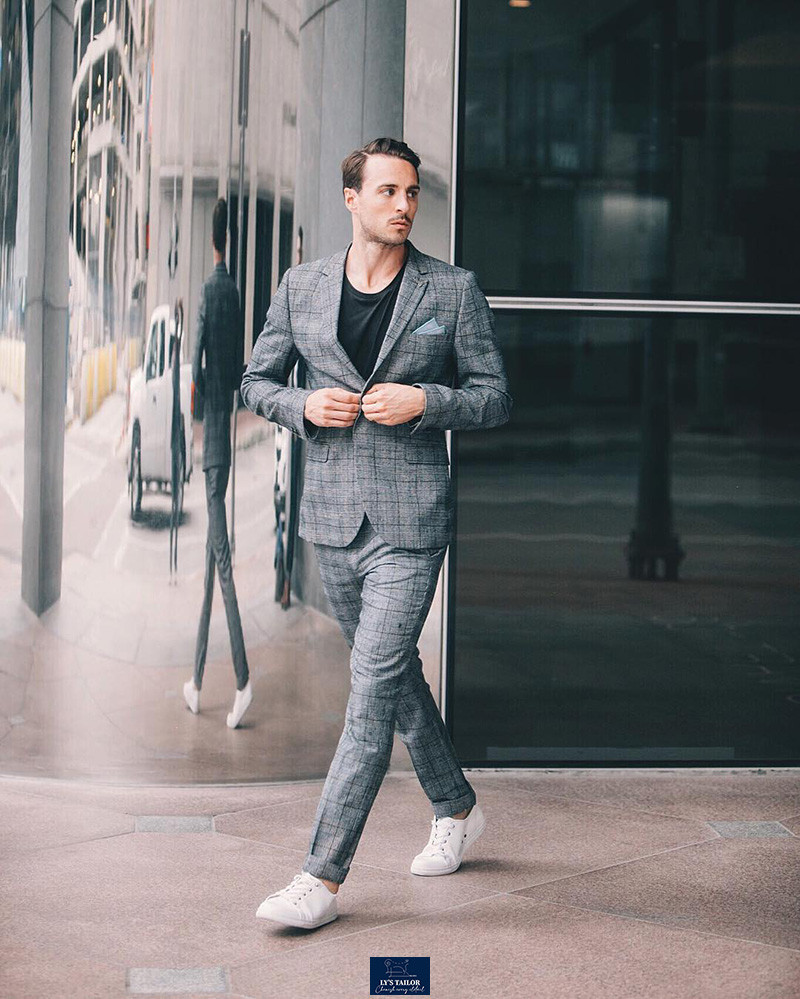 Người đàn ông mặc vest xám, áo phông trắng và giày sneaker trắng, tạo phong cách smart-casual