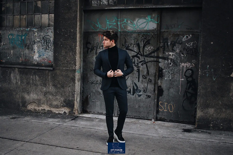 Người mẫu mặc vest và quần âu xanh than, phối cùng giày sneaker trắng cổ thấp, tạo vẻ ngoài năng động và thanh lịch