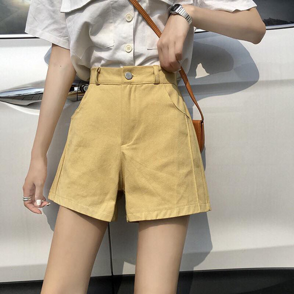 Quần short nữ kaki màu be và áo sơ mi trắng thanh lịch