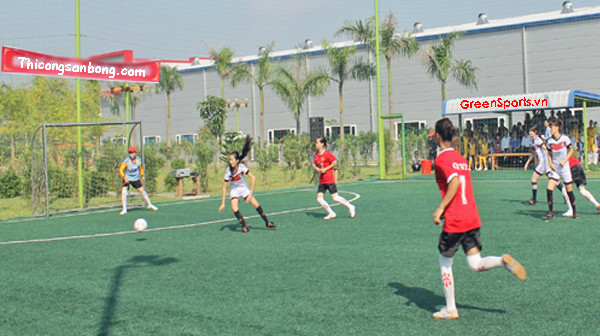 Sân bóng đá cỏ nhân tạo với các quảng cáo xung quanh, nơi các cầu thủ có thể thuê giày đá bóng chất lượng để thi đấu.