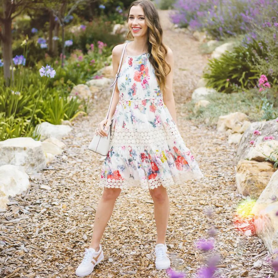 Vẻ đẹp nữ tính của váy hoa đỏ rực rỡ kết hợp cùng giày thể thao trắng đơn giản, tạo điểm nhấn thu hút.