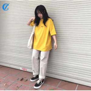 Một cô gái mặc áo thun form rộng sọc ngang và quần baggy jeans xanh nhạt