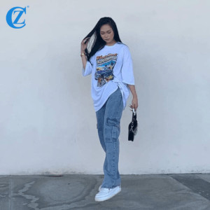Một cô gái trẻ mặc áo thun form rộng màu trắng và quần jeans ống đứng